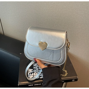 Detail of silver square crossbody bag with heart buckle and metallic chain strap