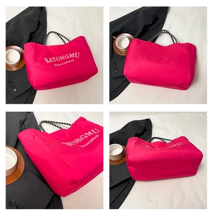 Detail of bright pink waterproof tote bag featuring woven handles and white lettering