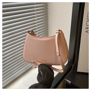 Détail du sac sous le bras rose en forme de croissant avec lettrage FASHION doré