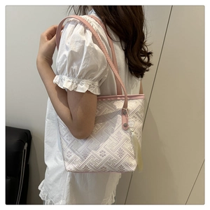Detail of Chinese style embroidery tote bag with pink leather handles and tassel charm