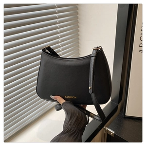 Détail du sac sous le bras en cuir noir avec bandoulière réglable et ferrures dorées