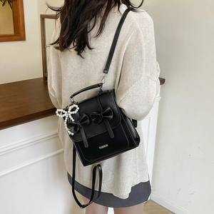 Women's black faux leather backpack with bow knots and pearl pendant in casual style