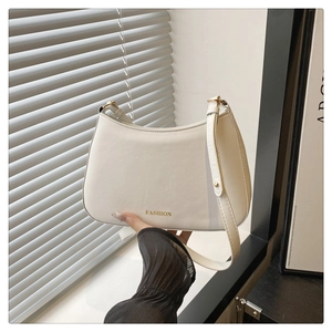 Détail d'un sac hobo blanc avec texte FASHION doré et bandoulière réglable
