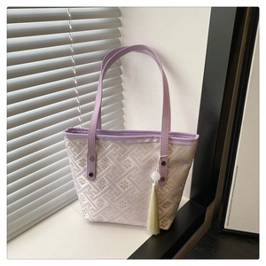 Close-up of purple jacquard tote bag with elegant tassel charm and bead decoration