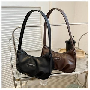 Detail of black and brown pleated shoulder bags with Fashion & Bag logo on a glass shelf