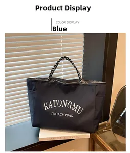 Detail of blue nylon tote bag showing white graphic text and braided rope handles