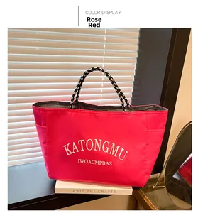 Detail of rose red nylon tote bag featuring durable woven rope handles and side pocket