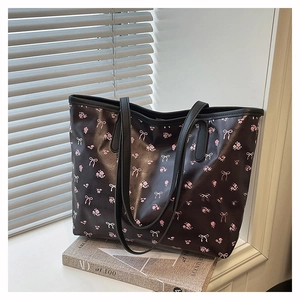 Detail of black floral tote bag with pink flower patterns and slim shoulder straps