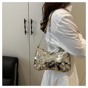 Detail of silver sequin shoulder bag showing shimmering texture and wave shape