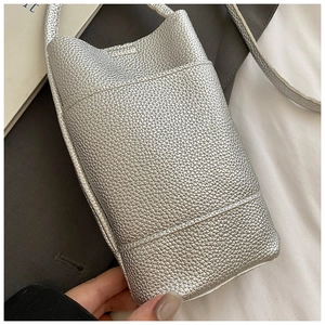 Detailed macro view of silver litchi grain leather and side pocket on this mini phone bag