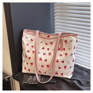 Detail view of floral and bear print tote bag placed on a book against a window