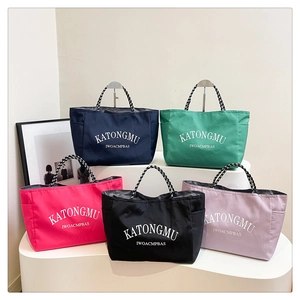 Detail of multi-color nylon tote bags showing stylish woven handles and side pockets