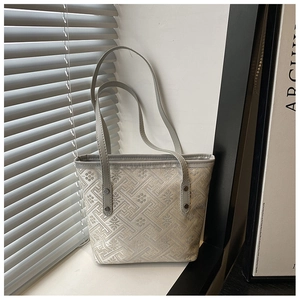 Macro view of woven geometric texture and durable leather handles on grey tote bag