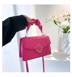 Detail of fuchsia quilted leather handbag with gold twist lock and ruffled handle wrap