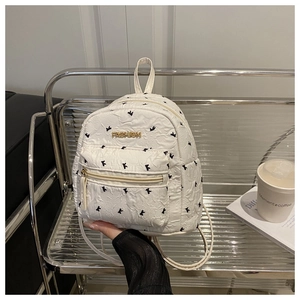 Mini white quilted backpack with bird embroidery and gold metal fashion logo detail