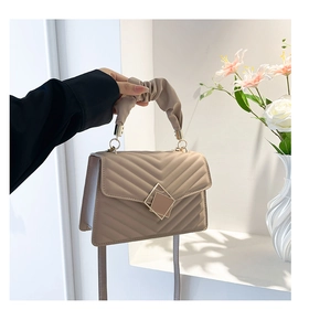Detail of beige crossbody bag with V-quilted pattern and pleated cloud handle handle