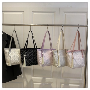Detail view of five color options for large embroidered tote bags with tassel charms