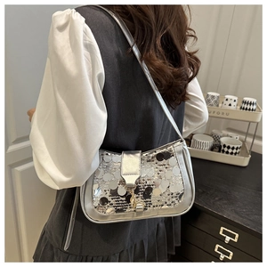 Close-up of stylish silver and black sequins on a chic baguette shoulder bag for women