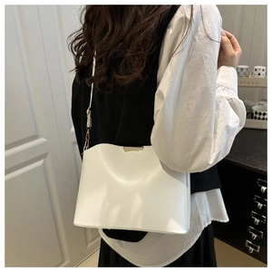 Minimalistische weiße Schultertasche aus Leder mit Goldverschluss an einem Model