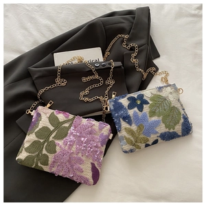 Close-up of elegant floral embroidery and sparkling sequins on textured chain bags