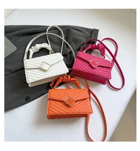Detail of quilted leather bags with gold square clasps and ruffled handles in three colors
