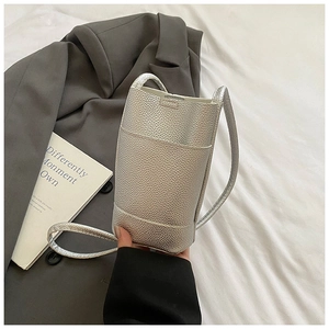 Close-up of silver litchi grain leather phone bag with front pocket and slim strap