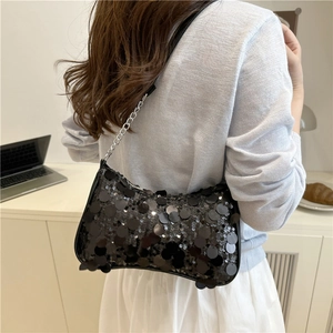 Sac sous le bras chic à paillettes noires avec chaîne argentée dans un cadre de vie moderne
