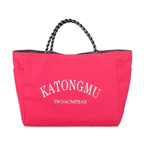 Pink nylon tote bag with bold white lettering and striped braided handles in front view