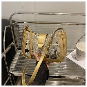 Detail of sequined baguette bag with golden metallic trim and silver round sequins