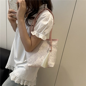 Elegant beige jacquard tote bag with geometric patterns and pink leather straps