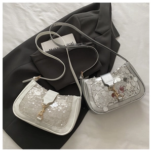 Close-up of cream and silver sequined shoulder bags with golden metallic hook closures