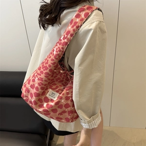 Pink leopard print tote bag with wide straps shown on model in stylish casual outfit