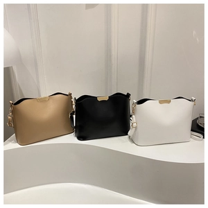 Plusieurs modèles de sacs bandoulière minimalistes en marron, noir et blanc exposés