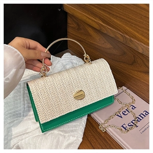 Detail of green leather crossbody bag with straw flap and golden chain strap