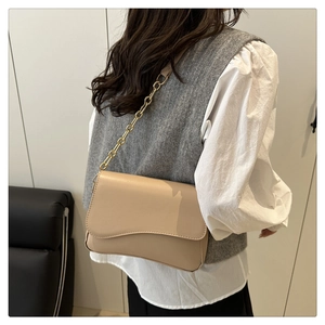 Borsa a tracolla minimalista in pelle beige con patta ondulata e catena dorata