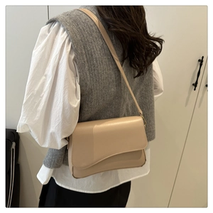 Detail einer minimalistischen beigen PU-Leder Umhängetasche mit gewellter Klappe für Damen
