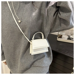 Close-up of white micro PU leather crossbody bag featuring a classic square flap and top handle
