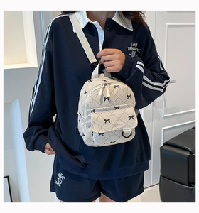 Detail eines Cord-Mini-Rucksacks mit schwarzen Schleifenmustern und Bändern