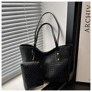 Detail of woven black tote bag with matching pouch and gold rivet accents