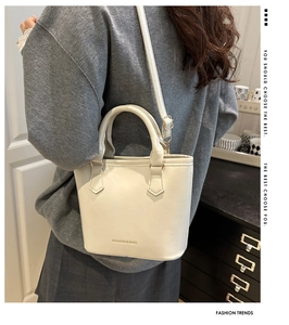Détail d'un sac seau chic blanc crème avec poignée et bandoulière réglable