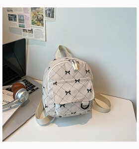 Detail eines Cord-Rucksacks mit Schleifen-Stickerei und Schnallentasche im Lifestyle-Stil
