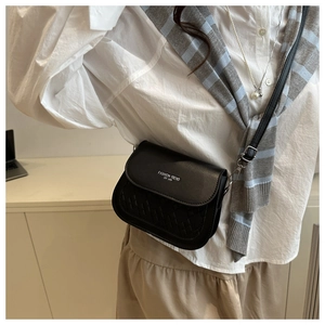 Detail of black semi-circle crossbody bag with quilted pattern and FASHION lettering
