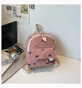 Detailansicht eines rosa Cord-Rucksacks mit süßen schwarzen Schleifen und Karomuster