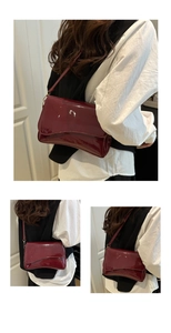 Detail of burgundy patent leather shoulder bag with wavy flap and glossy finish