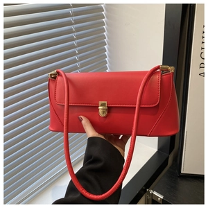 Detail of red leather baguette bag with premium gold metal square clasp and stitching
