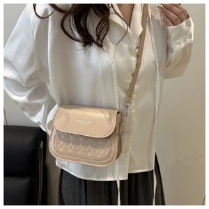 Close-up of beige quilted leather crossbody bag featuring Fashion Trend lettering