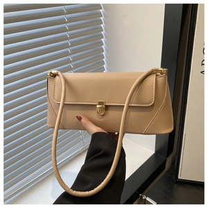 Close-up of beige faux leather baguette bag with elegant gold metal clasp and slim shoulder strap