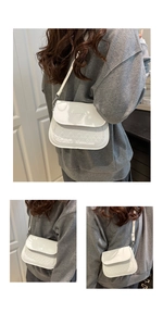 Detail of white crossbody bag featuring quilted texture and Fashion Trend embossed text