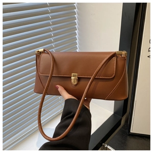 Detailed view of the vintage brown leather baguette bag with bright gold square buckle