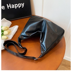 Détail du sac cabas en similicuir noir avec fermeture en V et boucle argentée sur bois